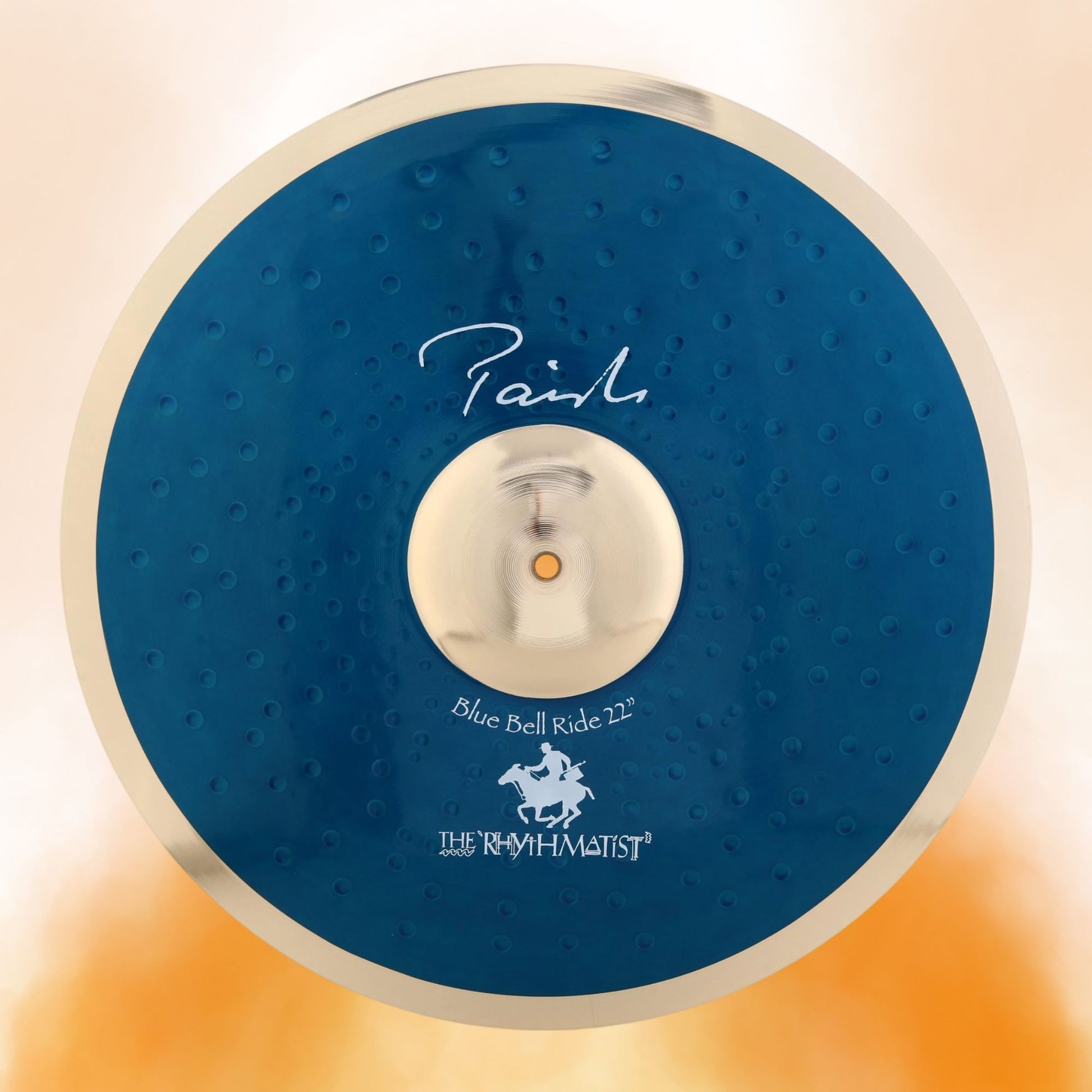 Front view of Paiste 22" Signature Blue Bell Ride Cymbal on orange background