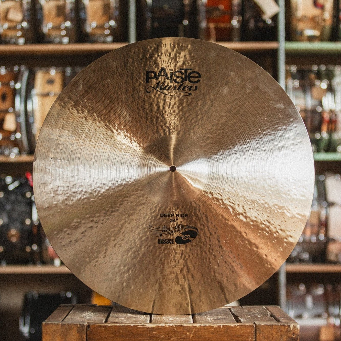 Front view of Paiste 24" Masters Deep Ride Cymbal on wooden crate in studio