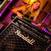 Close up view of Randall RG80 Combo Guitar Amplifier with guitarist in the background playing in studio