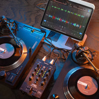 Angled top view of Reloop PTB-2 Portable 2+1-Channel DJ Mixer with DVS and Bluetooth connected to iPad and turntables in venue