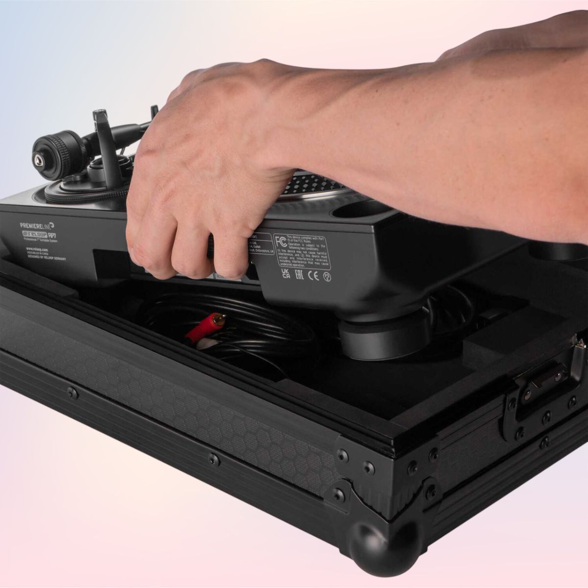 Person putting turntable inside Reloop Premium RP-7 Turntable Case on pink and purple background