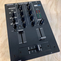 Angled view of Reloop RMX-10 BT Compact Bluetooth DJ Mixer on wooden surface