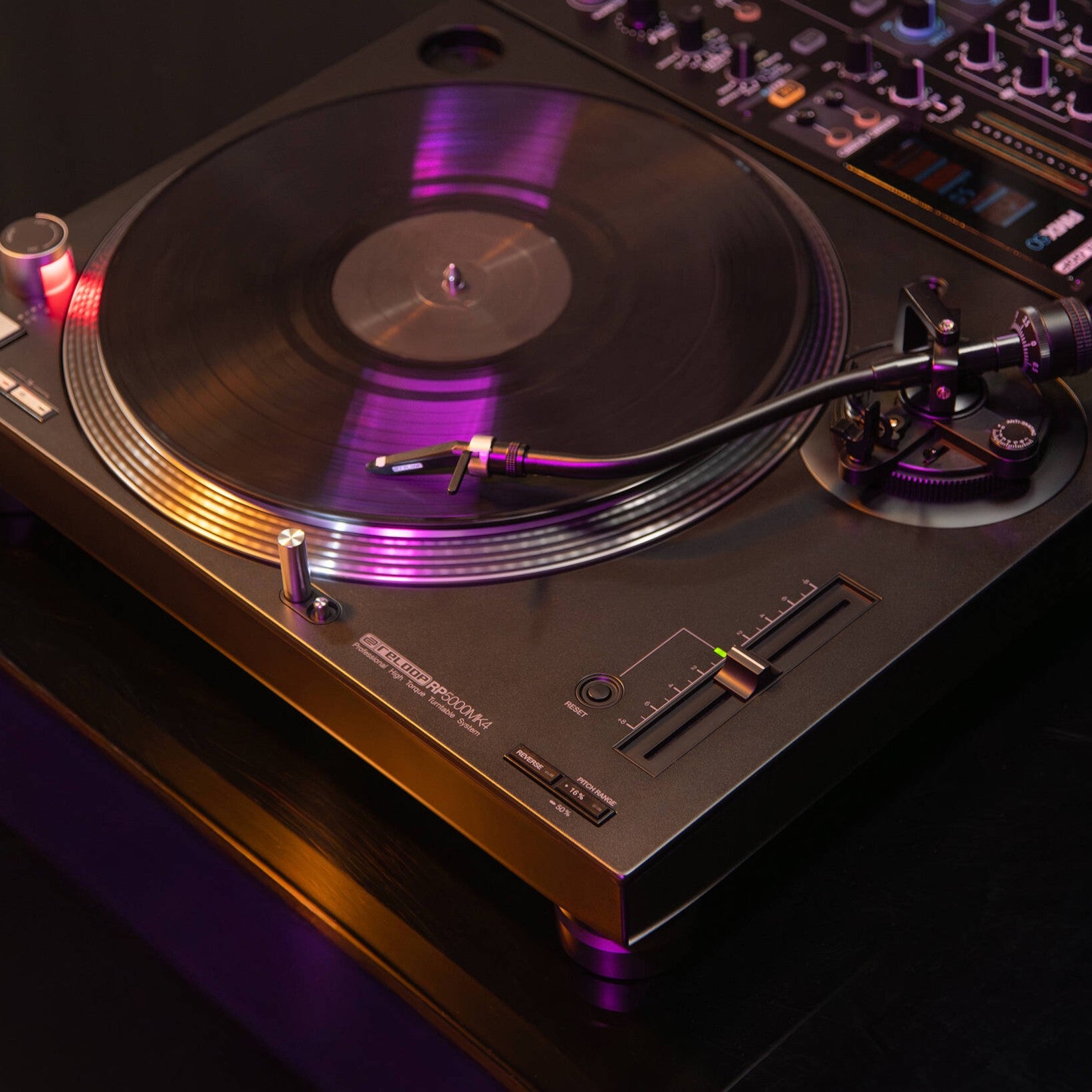 Angled view of Reloop RP-5000 MK4 Professional High-Torque Turntable System attached to DJ mixer in studio