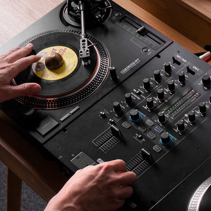 DJ playing with Reloop RP-7 Professional 7" Turntable System connected to DJ mixer on wooden surface