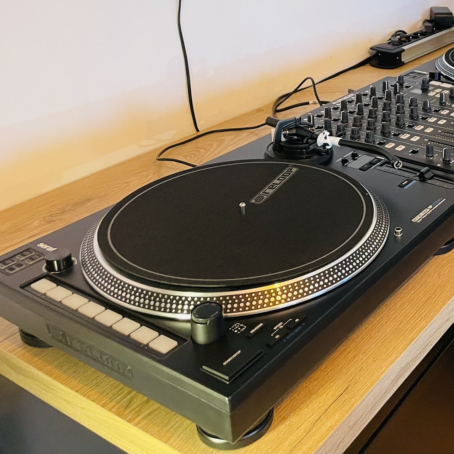 Reloop RP-8000 MK2 Upper Torque Hybrid Turntable Instrument connected to DJ mixer on wooden surface