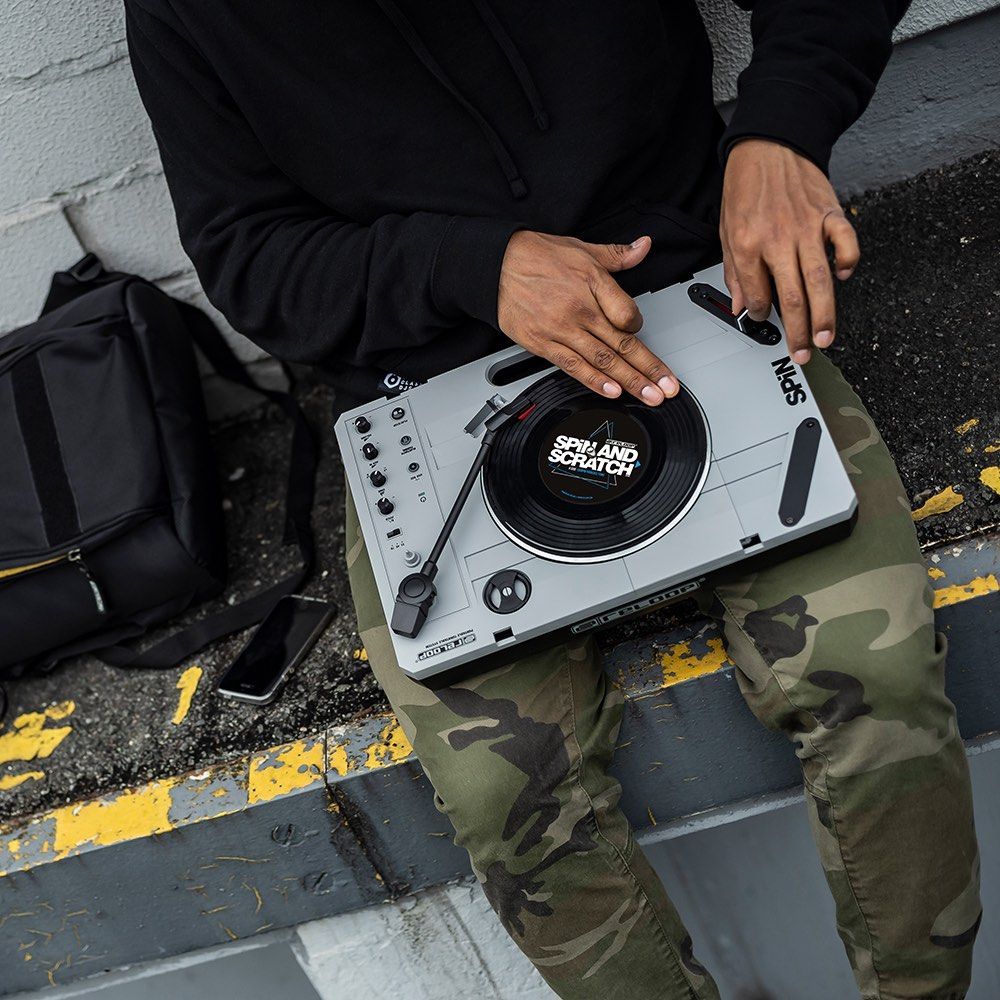 DJ using the Reloop SPiN Portable Turntable System outdoor