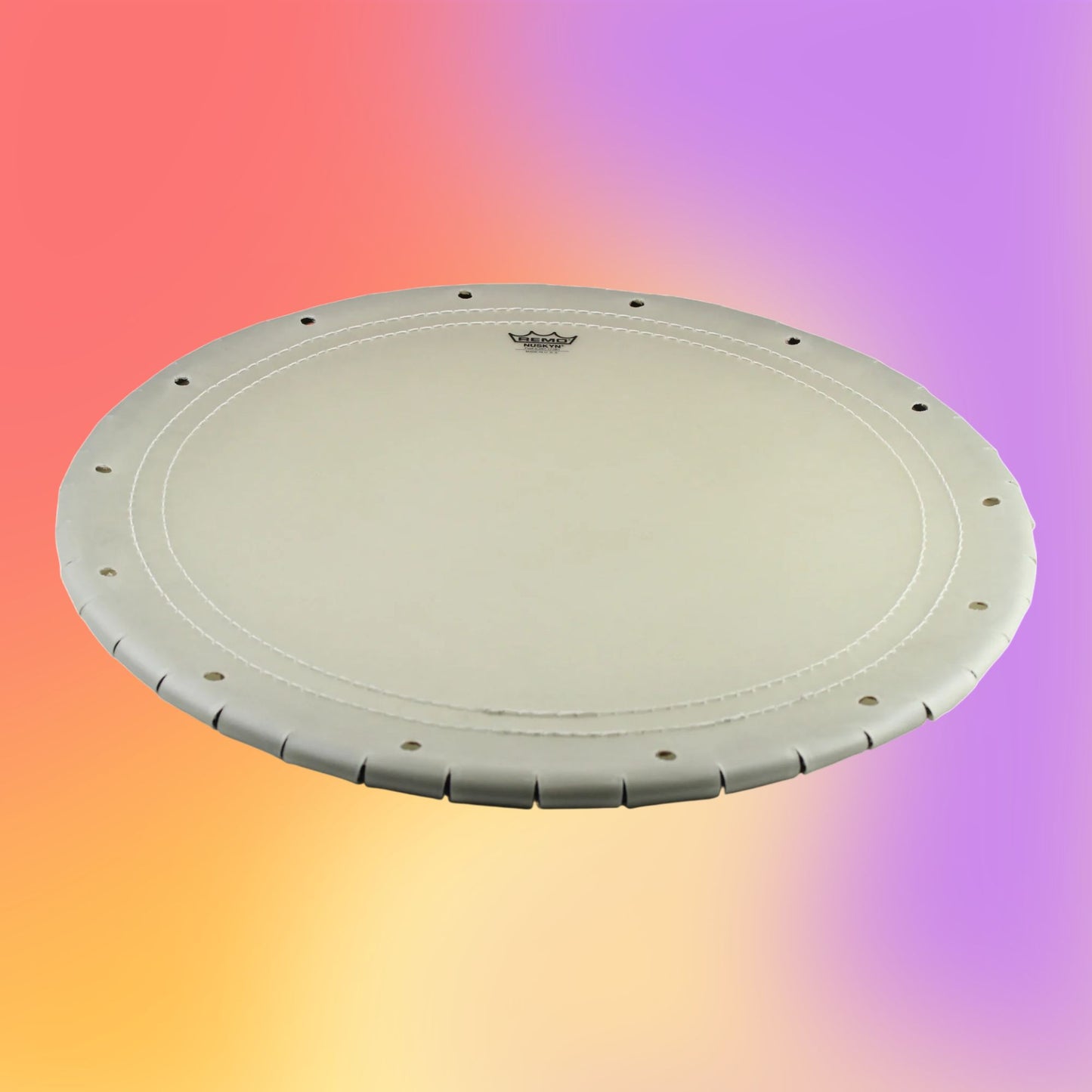 Angled view of Remo Taiko Drumhead Nagado Daiko Nuskyn 24“ Outer, 20” Crown, Light on multicolored background