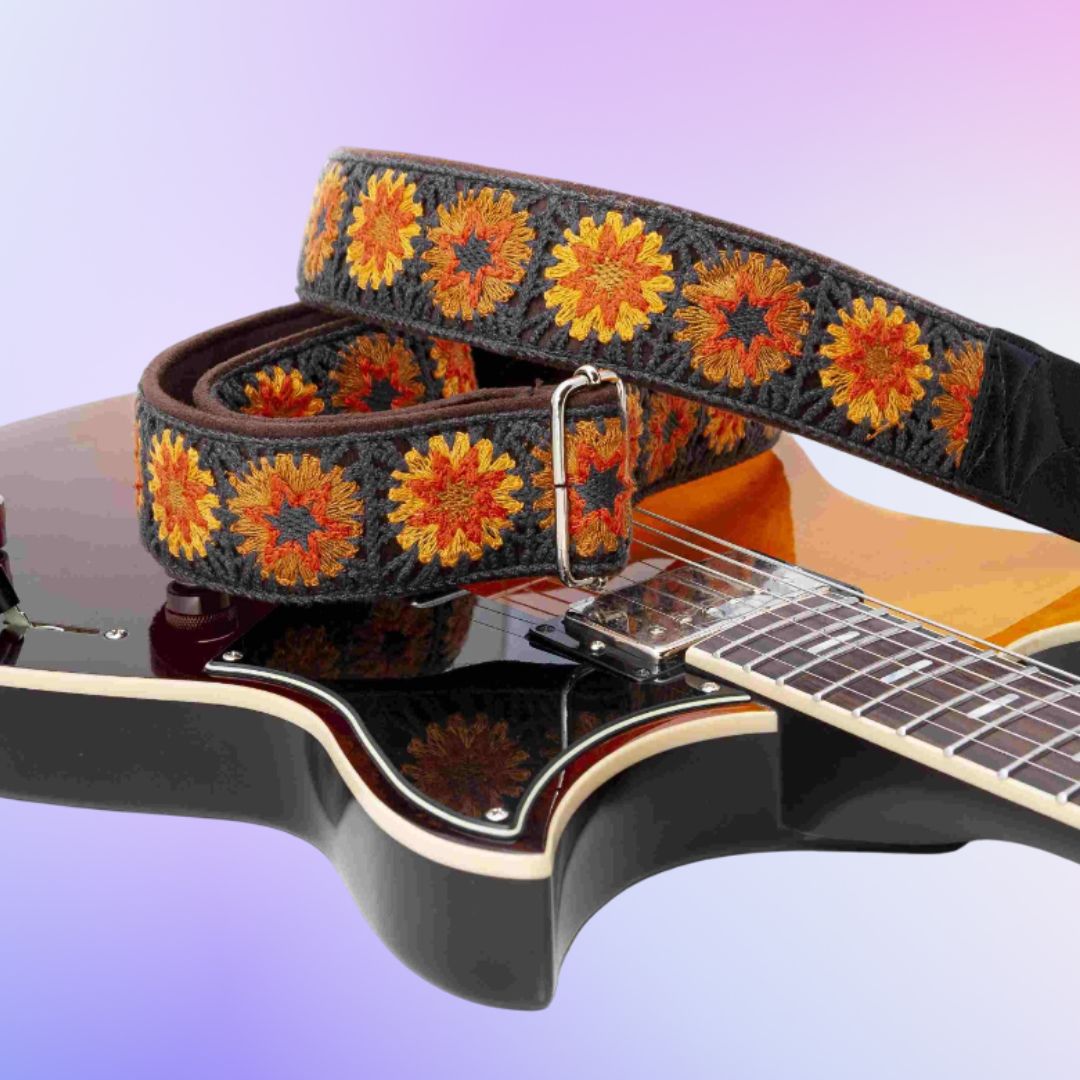 RightOn Crochet Guitar Strap Brown on top of guitar with purple background