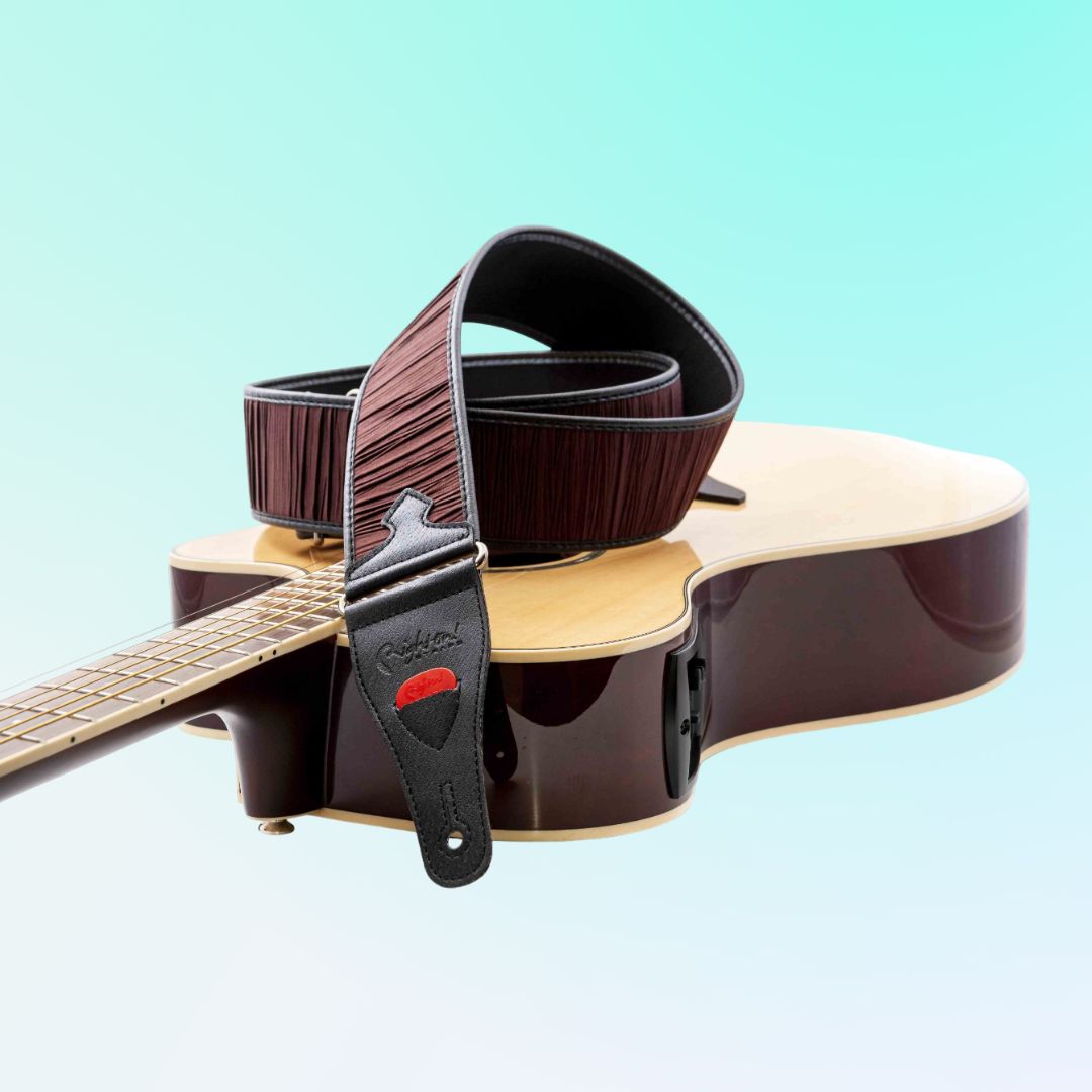 The RightOn Dune Guitar Strap (Brown) attached on an acoustic guitar with blue background
