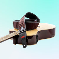 The RightOn Dune Guitar Strap (Brown) attached on an acoustic guitar with blue background