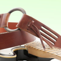 Close up view of RightOn Legend D.A. Guitar Strap on top of guitar with green background