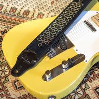 Top close up view of RightOn Sgt. Peppers Guitar Strap on guitar on patterned carpet