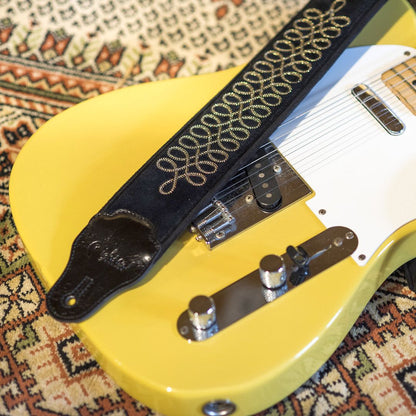 Top close up view of RightOn Sgt. Peppers Guitar Strap on guitar on patterned carpet