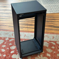 Black server rack on a wooden floor with a patterned rug