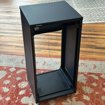 Black server rack on a wooden floor with a patterned rug