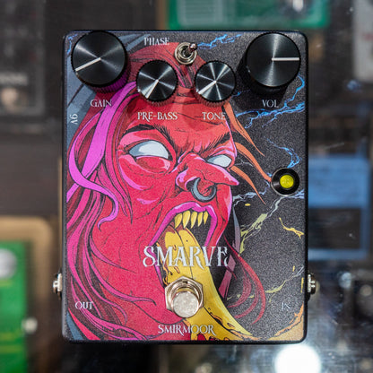 Front view of Smirmoor Smarve Pedal on glass case with pedals in the background