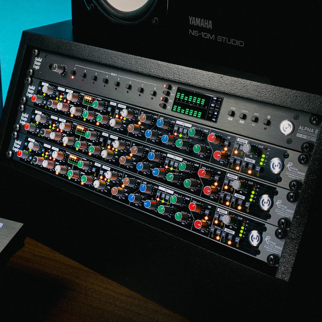 Multiple Solid State Logic Revival 4000 Analog Channel Strips in rack with other rack effects and a studio monitor on top of it