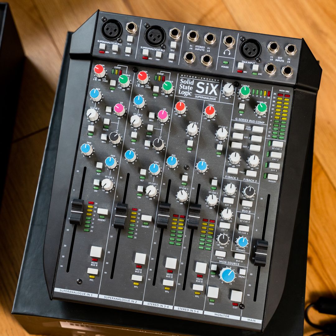Front view of Solid State Logic SiX Desktop Analog Mixer on top of box on wooden surface