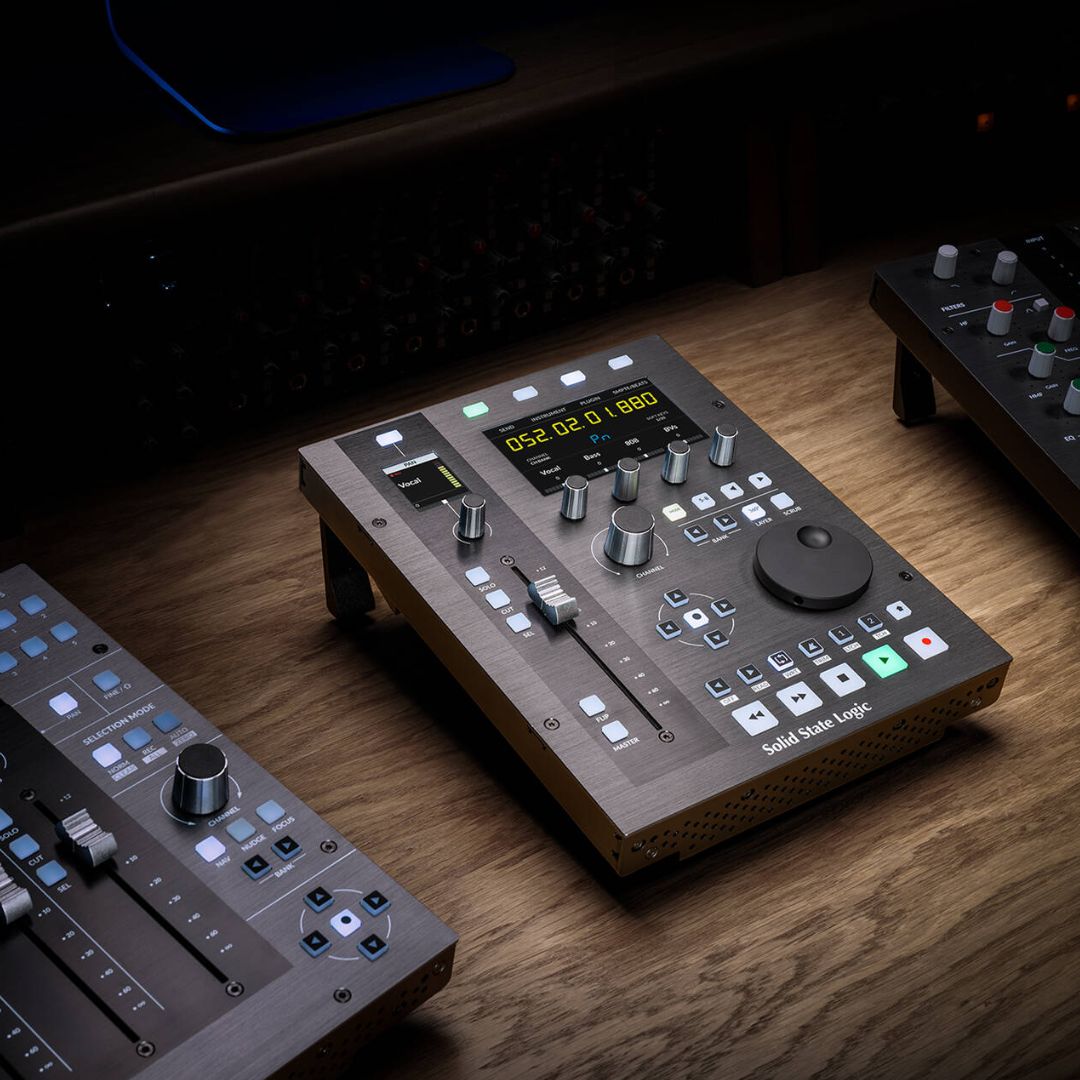 Angled front view of Solid State Logic UF1 Single Fader DAW Controller on wooden surface with other controllers beside it