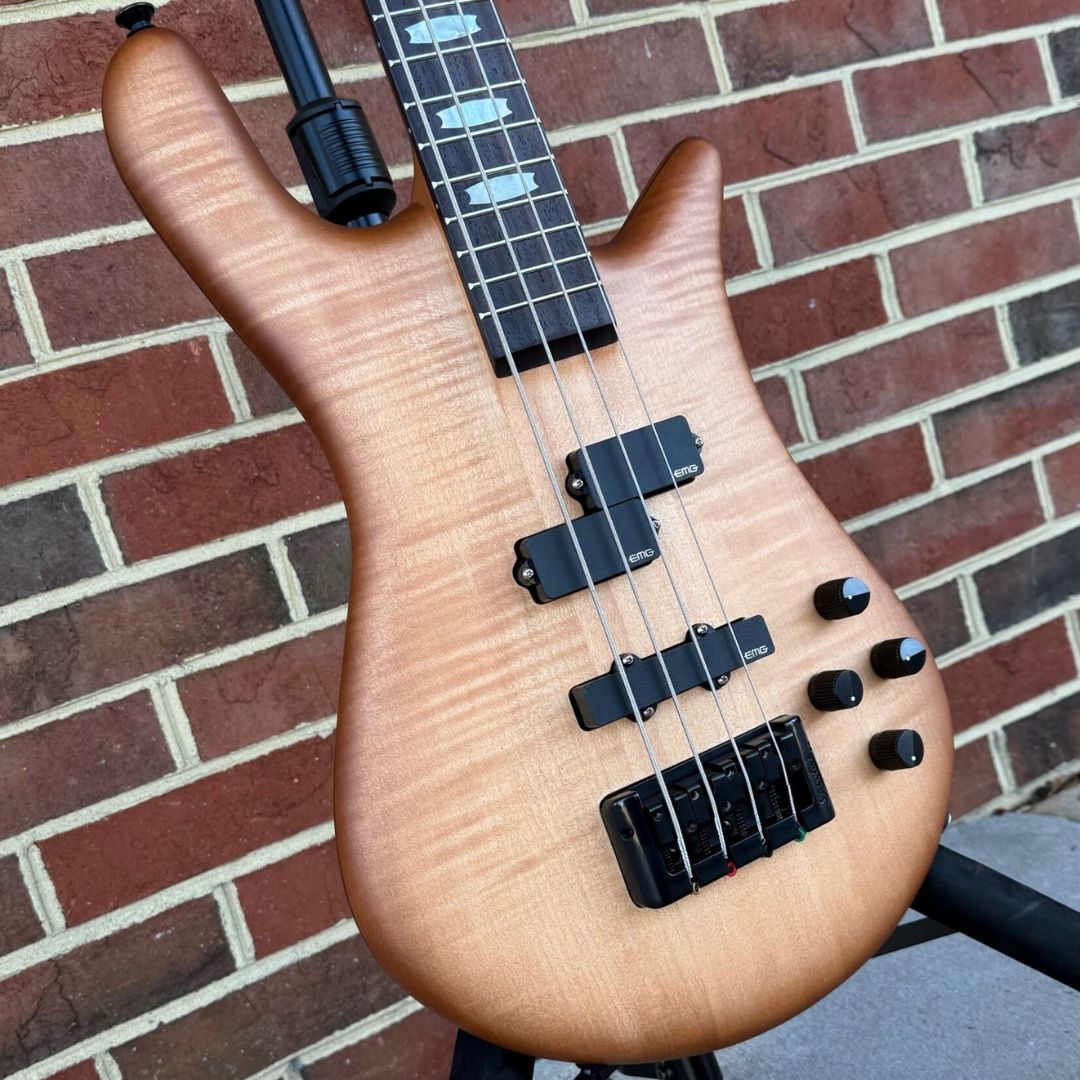 Angled close up front view of Spector Euro 4 LX Bass Guitar Natural Sunburst on brickwall background