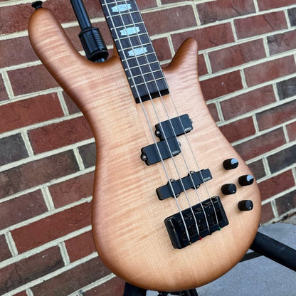 Angled close up front view of Spector Euro 4 LX Bass Guitar Natural Sunburst on brickwall background