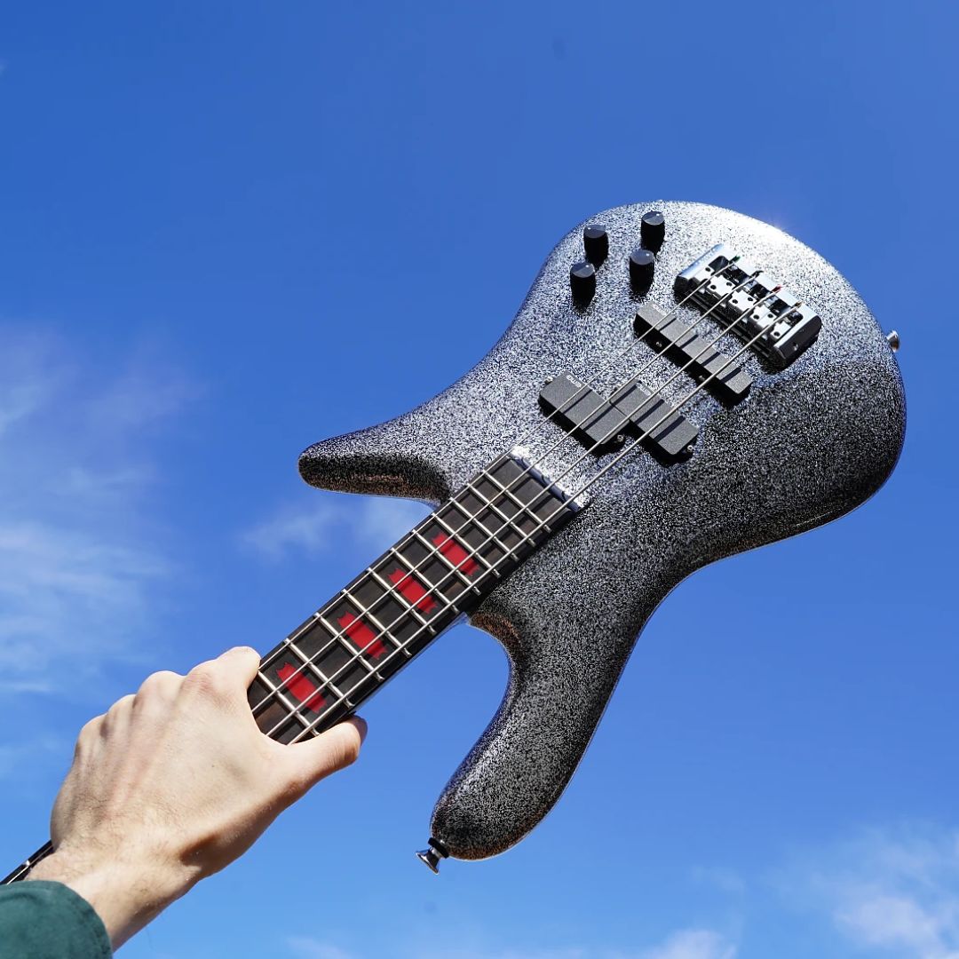 Hand raising Spector Euro4 Rachel Bolan Signature Bass Guitar in the air outdoors