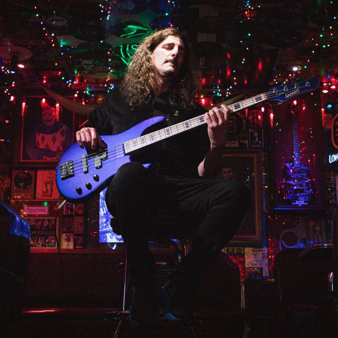 Frank Bello playing the Spector NC-4 Frank Bello Signature Bass Guitar in dim-lit bar