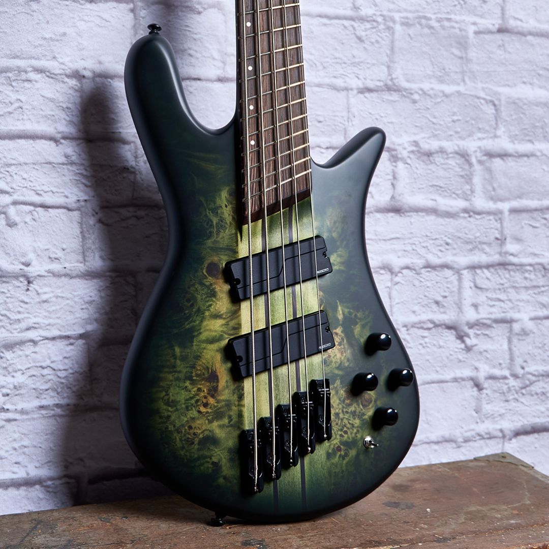 Close up front view of Spector NS Dimension 5-String Bass Guitar Haunted Moss Matte on wooden surface with white brick wall background