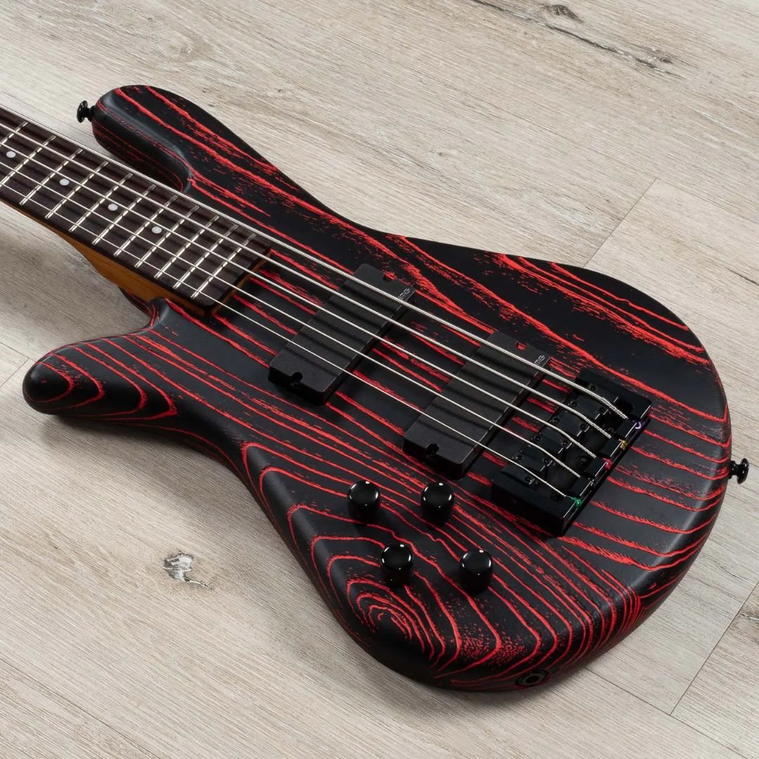Close up angled view of Spector NS Pulse 5-String Left-Handed Bass Guitar (Cinder Red) on wooden surface