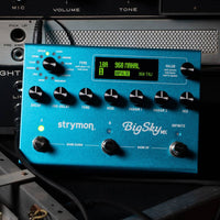 Top view of Strymon BigSky MX pedal on tour case with amplifier background