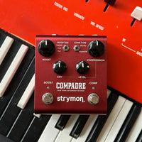 Front view of Strymon Compadre on top of red piano