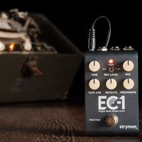 Front view of Strymon EC-1 on wooden surface with tape machine in the background
