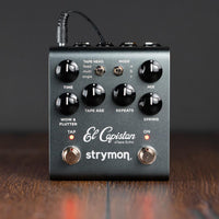 Front panel of Strymon El Capistan on wooden surface with grey background