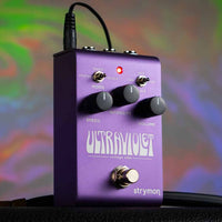 Angled front view of Strymon UltraViolet on top of amplifier with psychedelic background