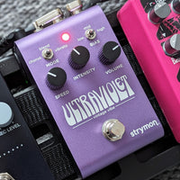 Angled front view of Strymon UltraViolet mounted on pedalboard with other pedals beside it
