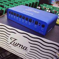 Angled view of Strymon Zuma on top of its box with chipsets in the background