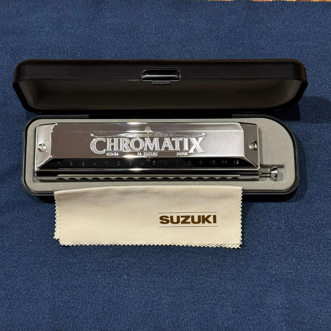 Inclusions view of Suzuki SCX-64 Chromatic 16 Hole Harmonica on blue background