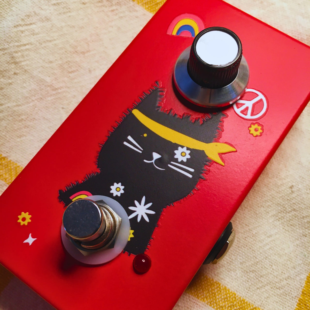 Close up angled view of TONECAT Cosmo Phaser Pedal on beige cloth with yellow stripes