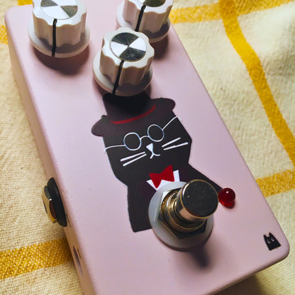 Close up angled view of TONECAT Hugo Overdrive Pedal on beige cloth with yellow stripes