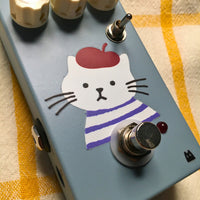 Close up angled view of TONECAT Luna Overdrive Pedal on beige cloth with yellow stripes