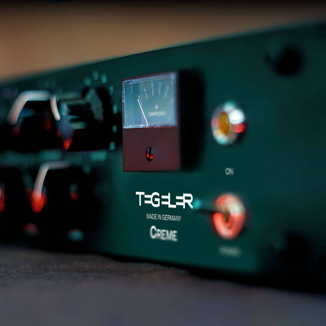 Angled close up view of Tegeler Creme Bus Compressor and Mastering Equalizer on black surface