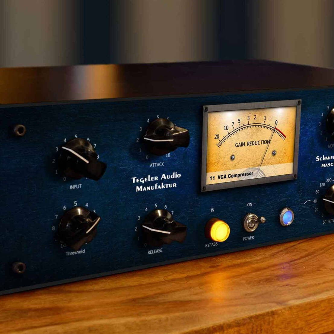 Close up angled view of Tegeler Remote Controllable Vari-Mu Mastering and Bus Compressor on wooden surface in studio