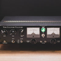 Close up of rackmount effect front panel on top of wooden table with a dark background