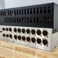 Angled close up shot of rear panel of rackmount effect on wooden table and gray background