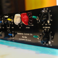 Close up angled view of front panel of black rackmount effect on top of blue table and orange background