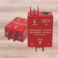 Two red DI boxes side by side on wooden panel background