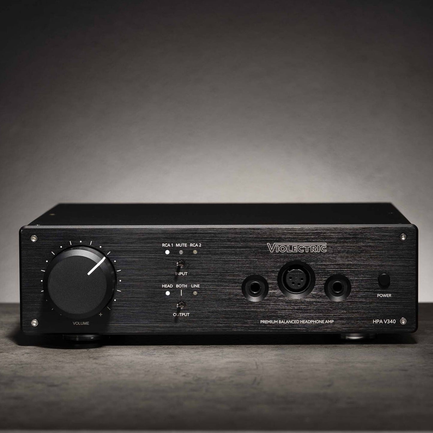 Front view of Violectric HPA V340 Headphone Amplifier on grey concrete surface