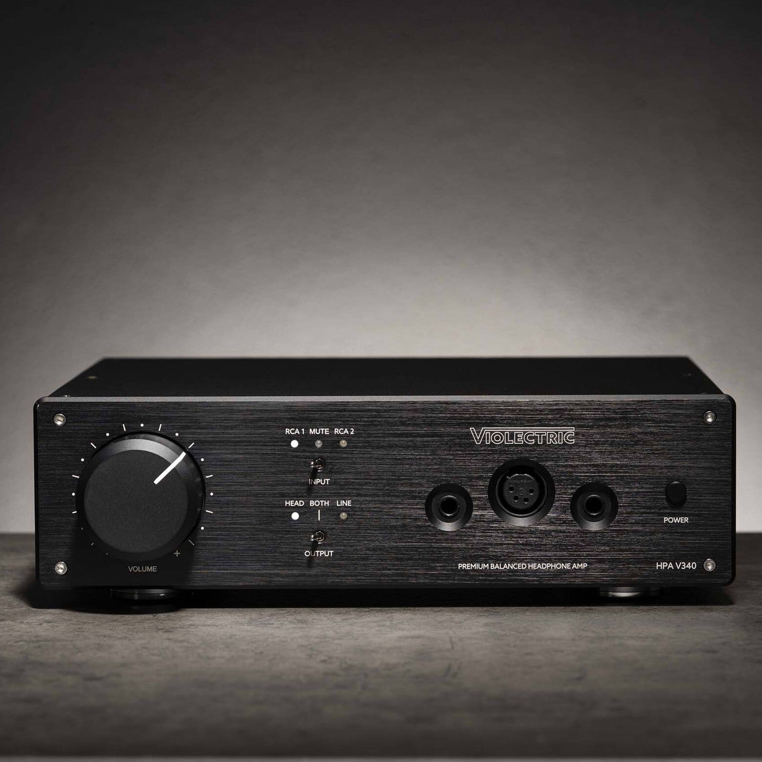 Front view of Violectric HPA V340 Headphone Amplifier on grey concrete surface