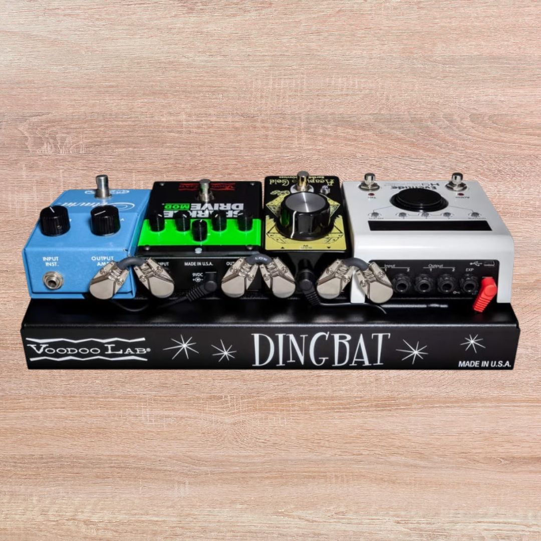 Front view of Voodoo Lab Dingbat TINY Pedalboard with pedals attached on wooden background