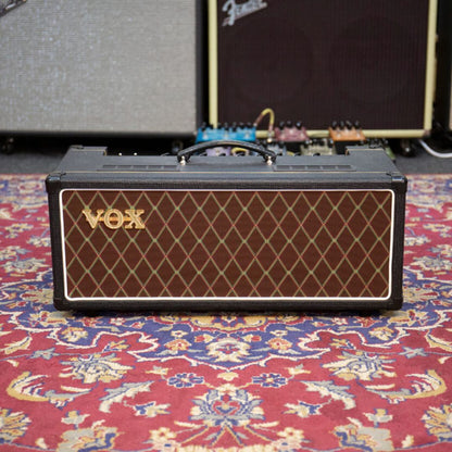 Front view of Vox AC15 Custom Tube Amplifier Head on paisley carpet with amplifiers and pedals in the background